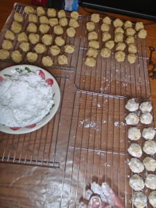 Dipping baked cookies in sugar.
